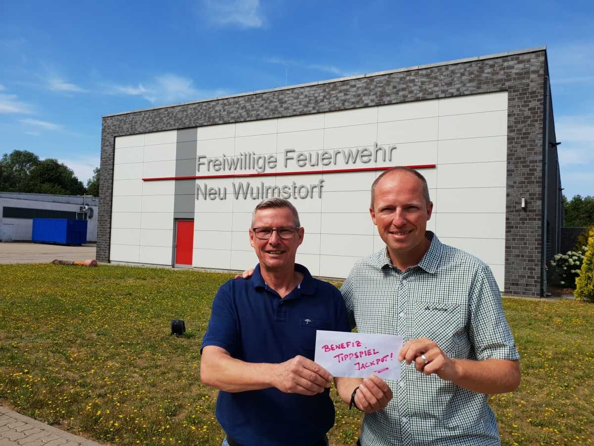 Tobias Handtke übergibt SPD-Benefiz-Tippspiel Gewinner Rudi Wölk den Jackpot für eine Spende an die Jugendfeuerwehr Neu Wulmstorf