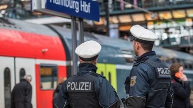 two police officers standing in front of a train