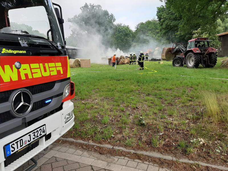 Heuballen brennen auf landwirtschaftlichem Gehöft in Deinste