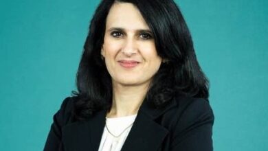 a woman with black hair wearing a black suit