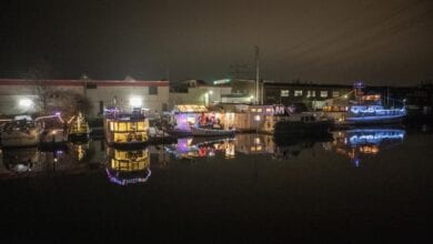 Weihnachtlich geschmückte Boote fahren durch den Harburger Binnenhafen