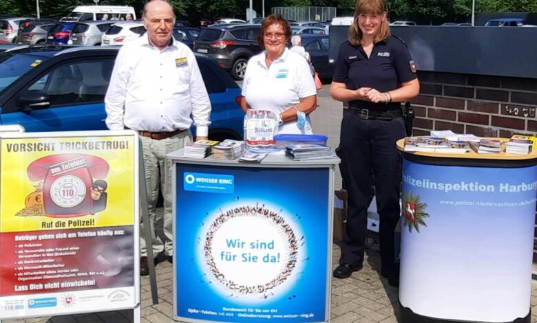 a group of people standing next to a sign