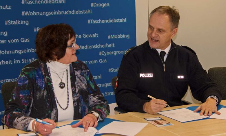 Das Bild zeigt zwei Menschen, die eine Vereinbarung unterzeichnen.