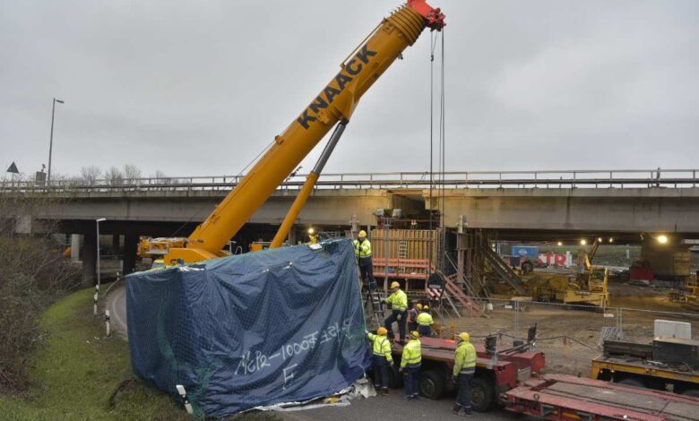 Ein Kran hebt ein zuvor verunglücktes Gut eines LKW von der Straße