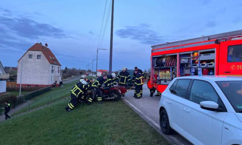 Die Unfallstelle am Deich, Feuerwehrleute bergen das Krad.
