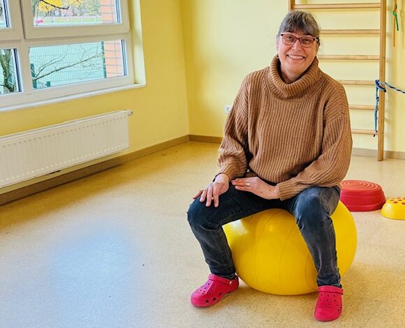 a woman sitting on a yellow ball