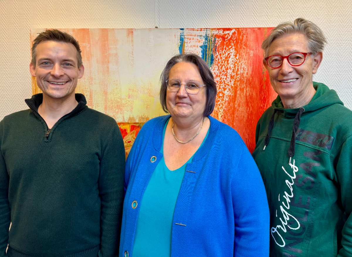 a group of people standing in front of a painting