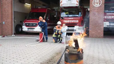 a group of firefighters and a child by a fire
