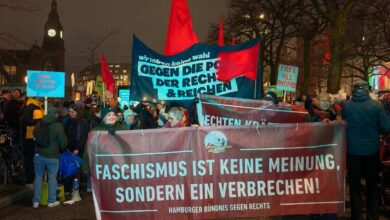 a group of people holding signs and a banner