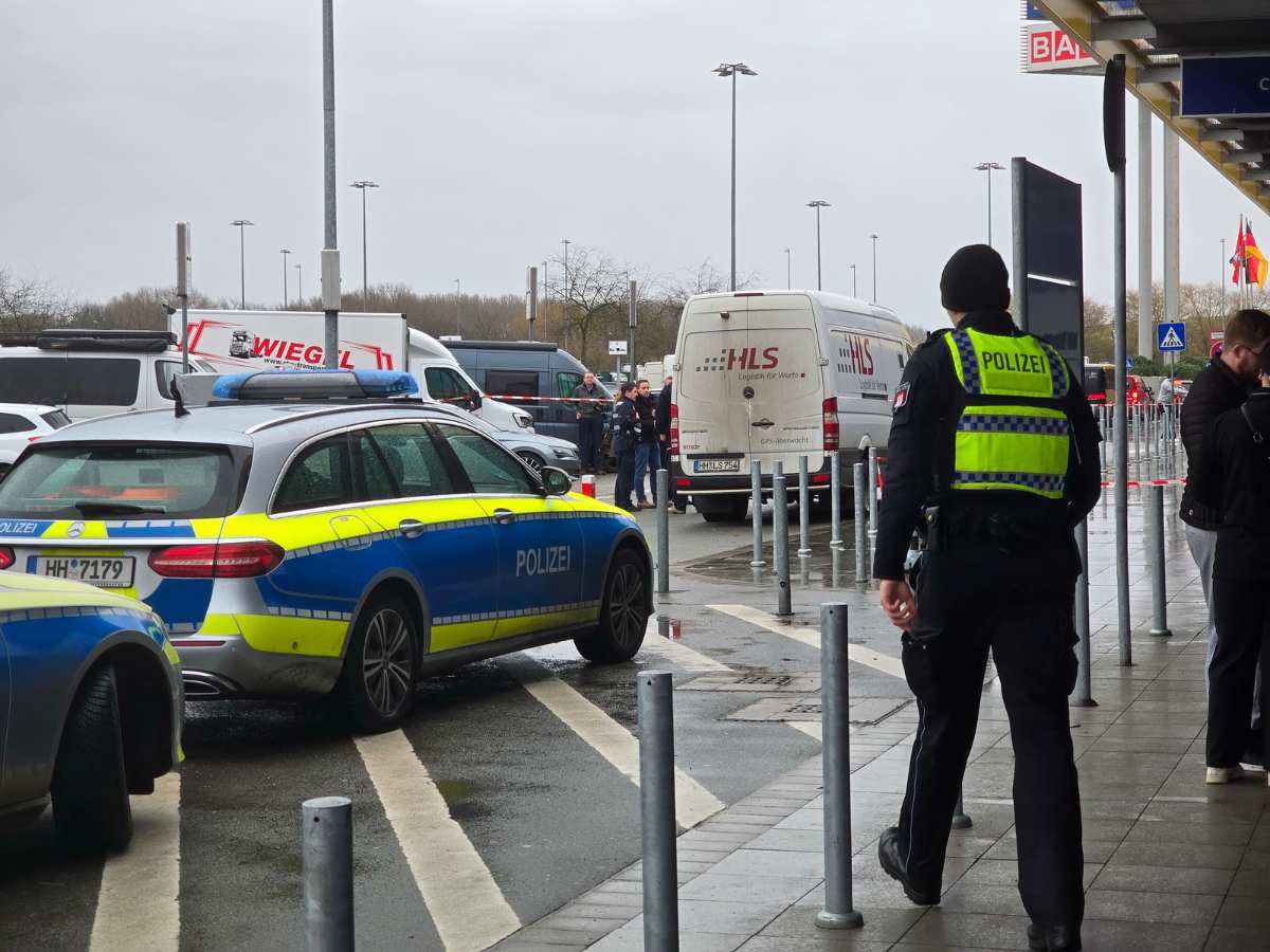 a police officer standing on a sidewalk with cars parked on the side