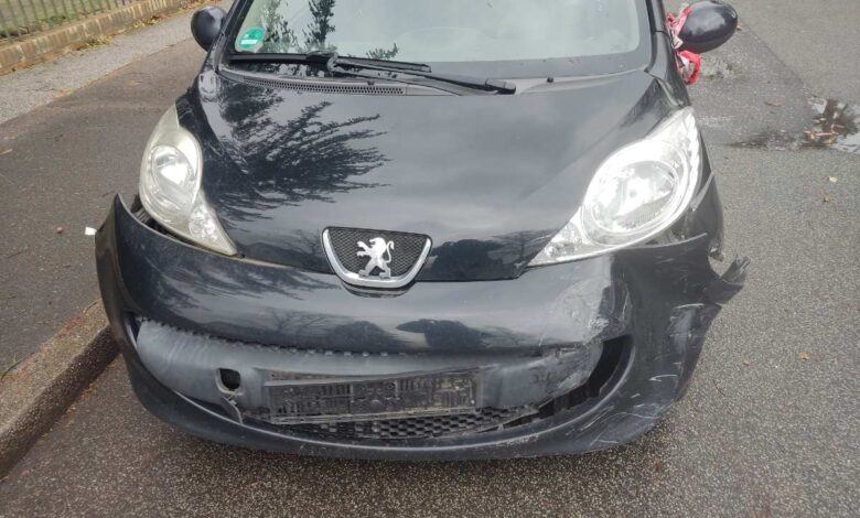 a black car with a dented front bumper