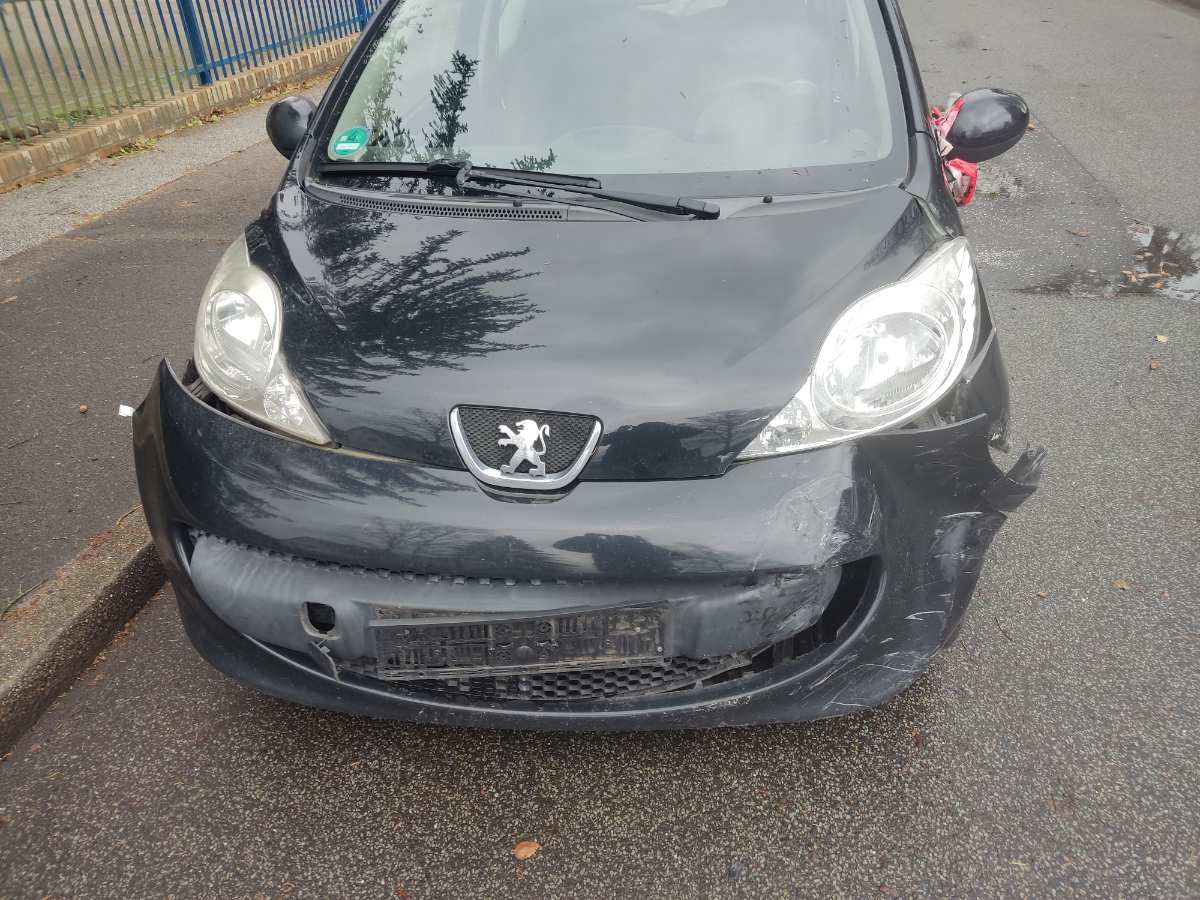 a black car with a dented front bumper