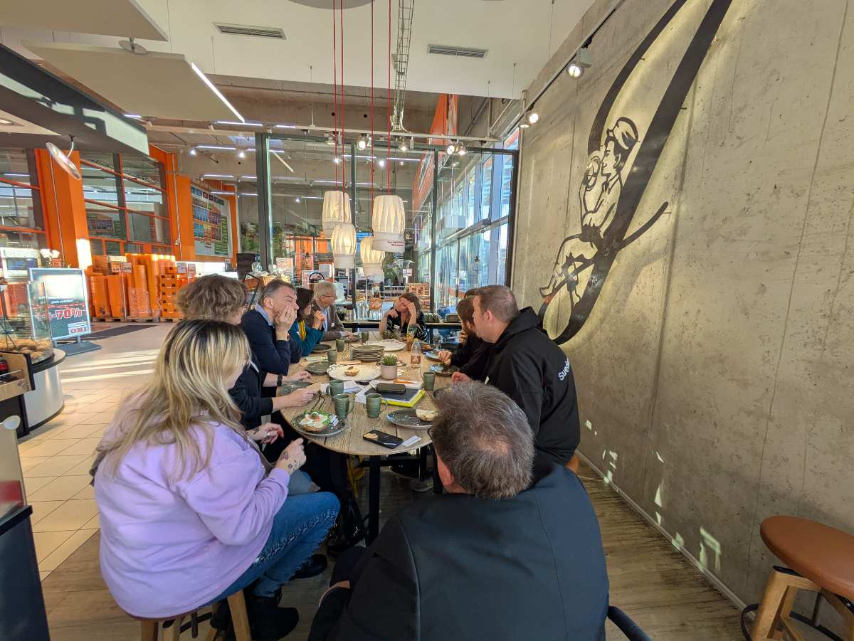 a group of people sitting around a table eating food
