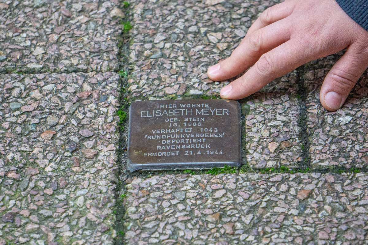 a hand touching a plaque on a stone surface