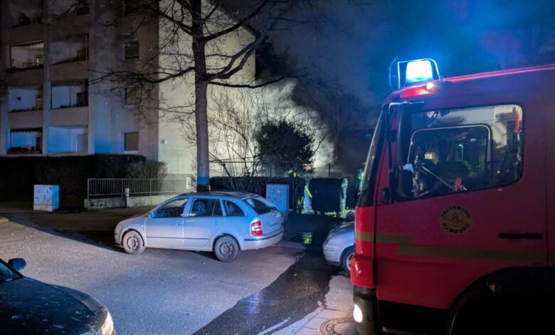 a fire truck and a car in a parking lot at night