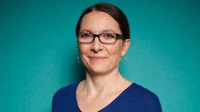 a woman wearing glasses and a blue shirt