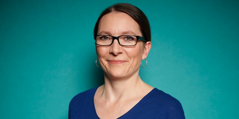 a woman wearing glasses and a blue shirt