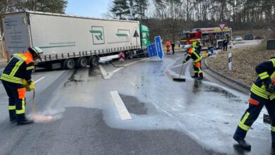 a group of firefighters cleaning a road with a truck