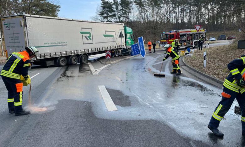 a group of firefighters cleaning a road with a truck