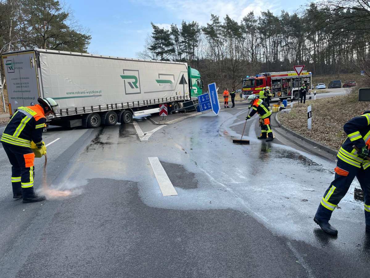 a group of firefighters cleaning a road with a truck