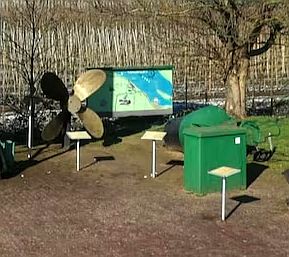 a propeller and trash cans in a park