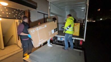 a group of people loading a box into a truck