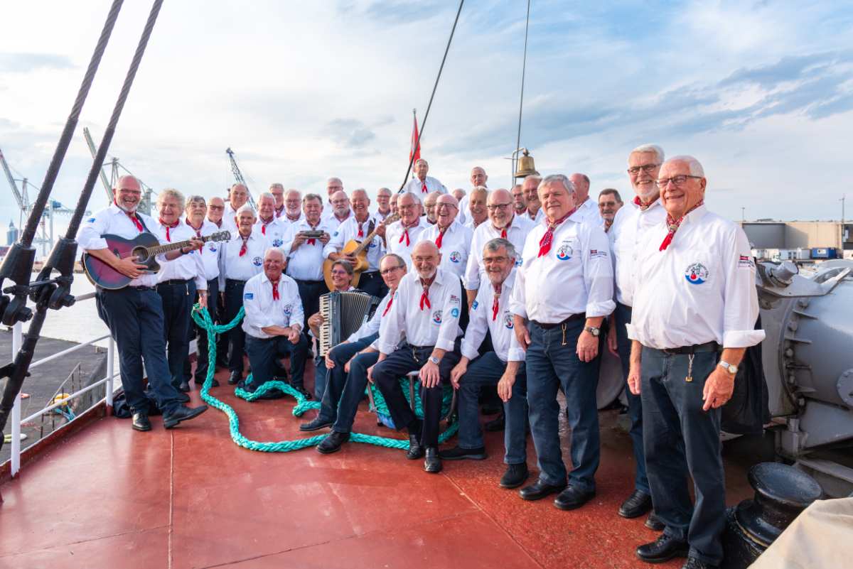 a group of men in white shirts and blue jeans