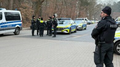 a group of police officers standing in front of a group of cars