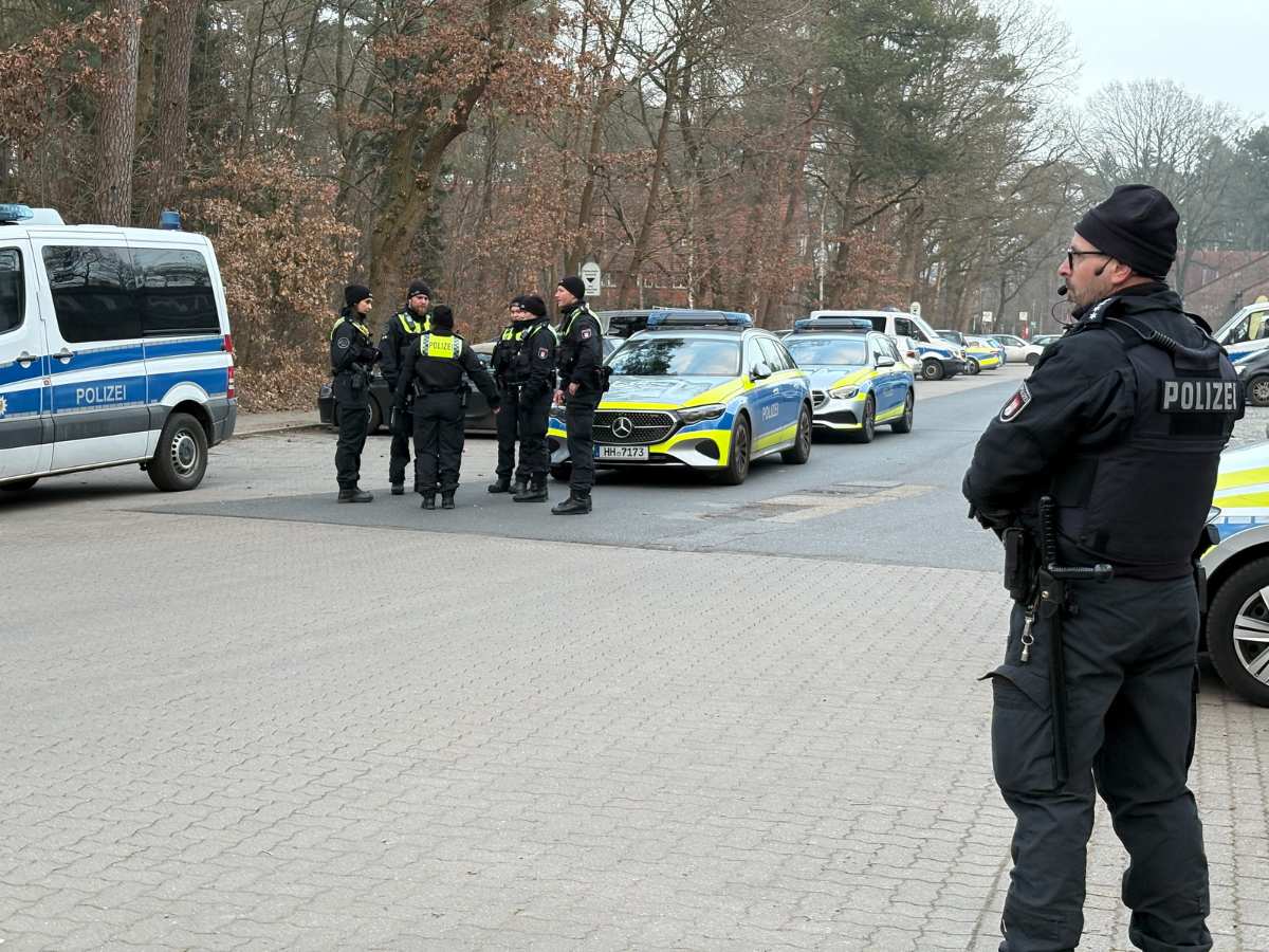 a group of police officers standing in front of a group of cars