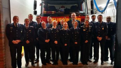 a group of people in uniform standing in front of a fire truck