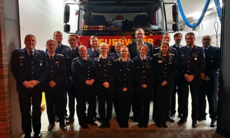 a group of people in uniform standing in front of a fire truck