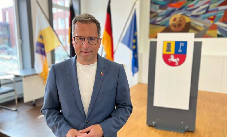 a man in a suit standing in front of flags