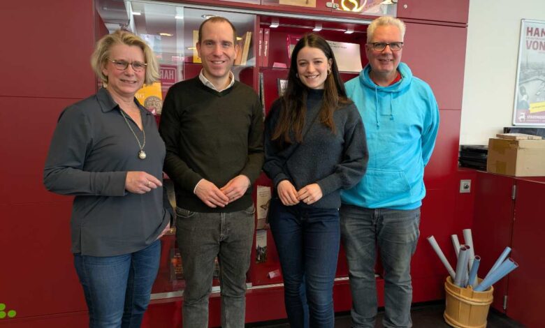 a group of people standing in front of a red cabinet