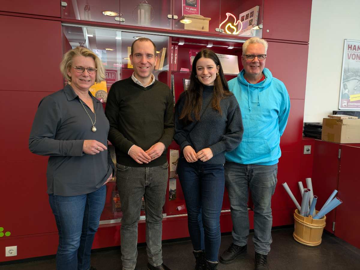 a group of people standing in front of a red cabinet