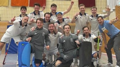 a group of men in sports uniforms posing for a photo