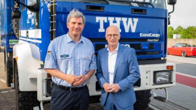 two men standing in front of a truck