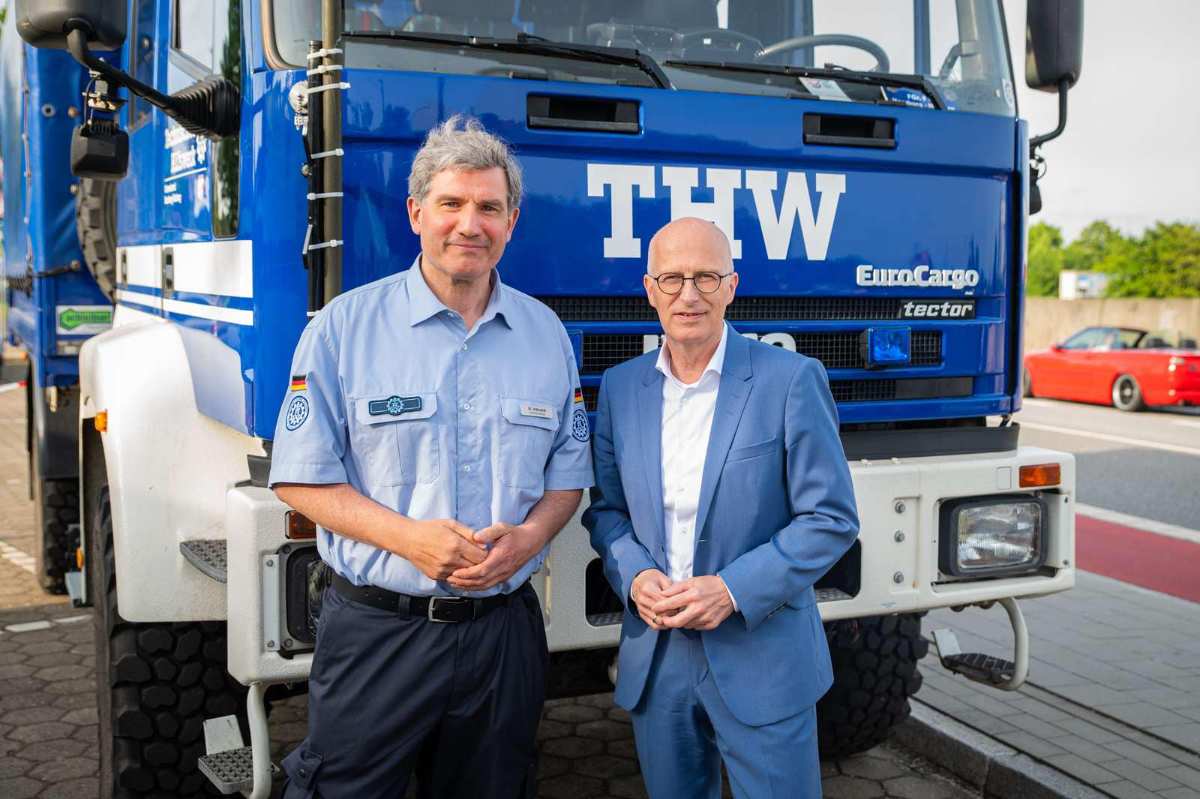 two men standing in front of a truck