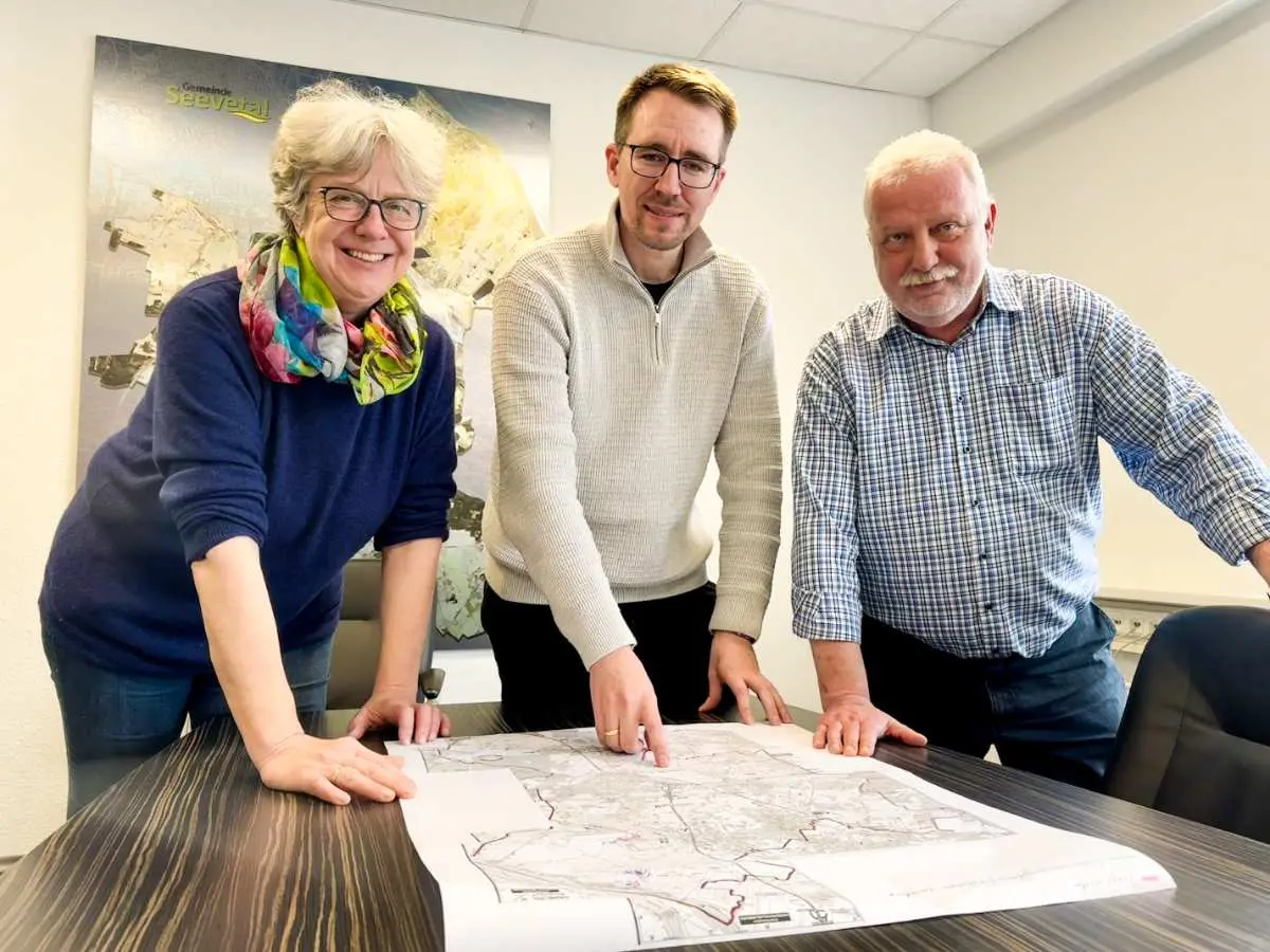 a group of people standing around a table with a map