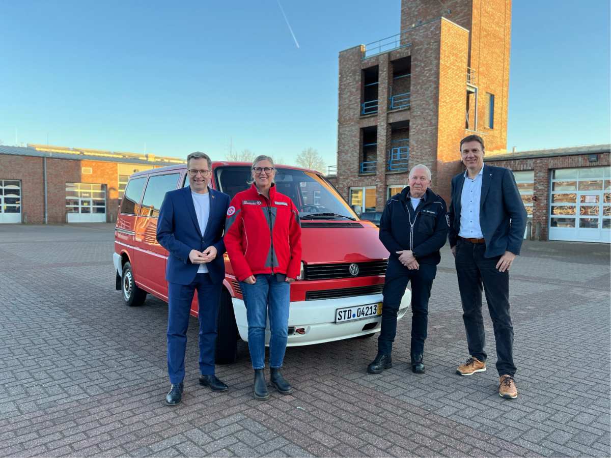 a group of people standing in front of a red van