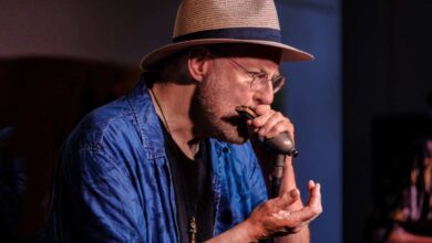 a man wearing a hat and holding a microphone