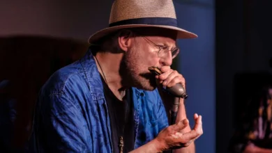 a man wearing a hat and holding a microphone