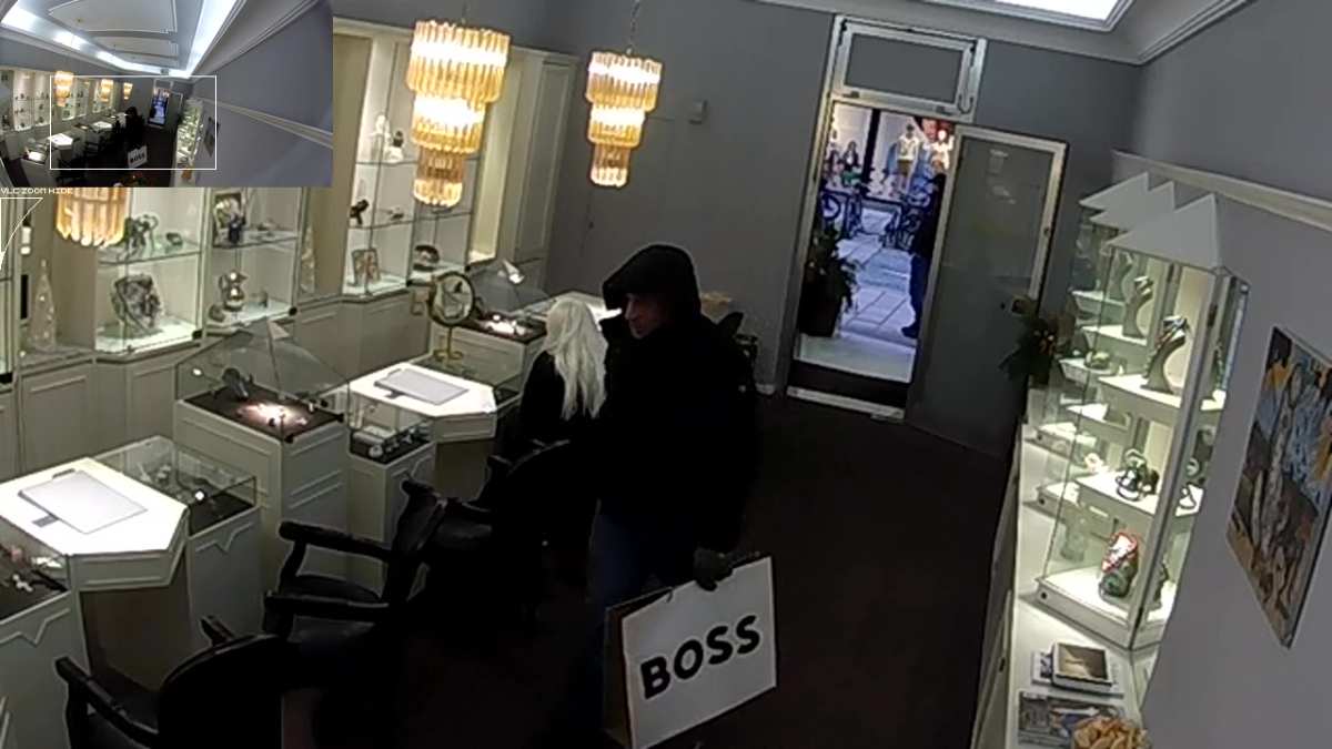 a man in a hoodie holding a sign in a store