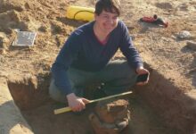 a man squatting in the sand