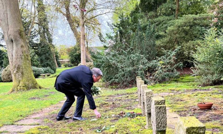 a man in a suit touching a grave