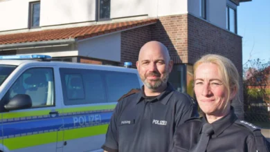 a man and woman standing in front of a police car