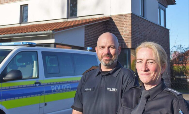 a man and woman standing in front of a police car