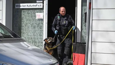 a man in uniform with a dog in the doorway of a building
