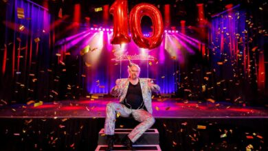 a man sitting on a stage with a balloon