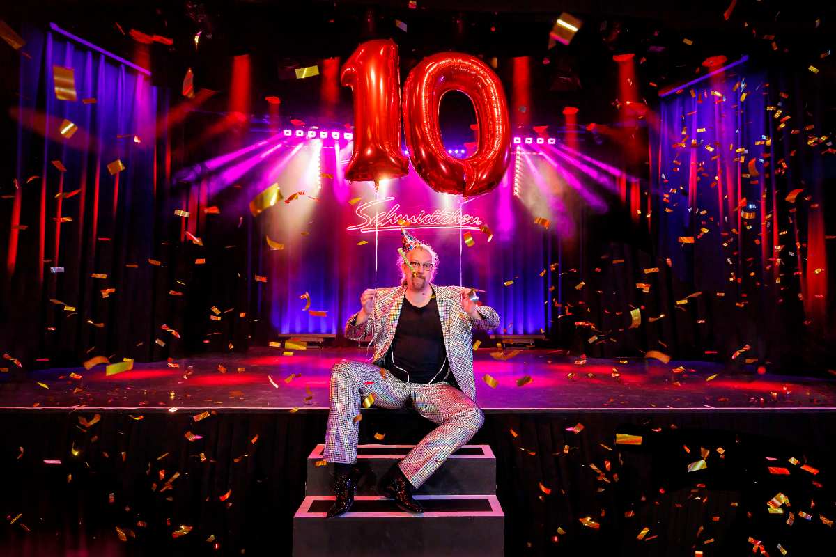 a man sitting on a stage with a balloon