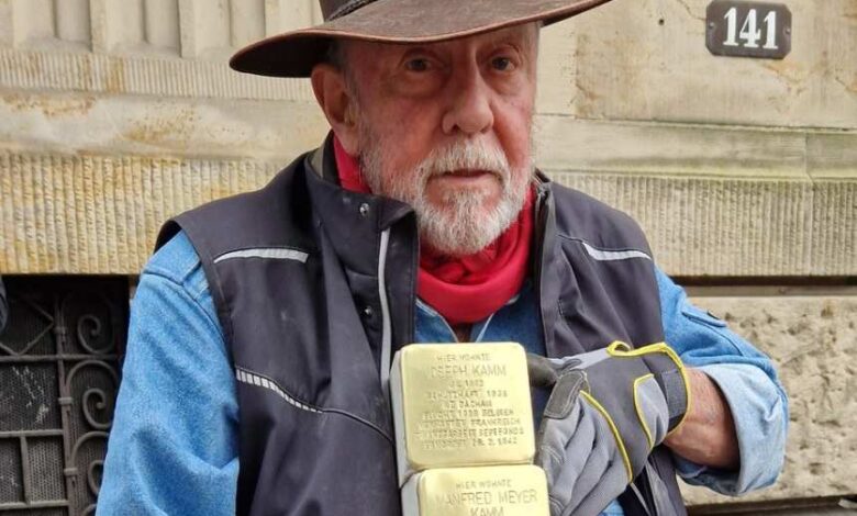 a man wearing a cowboy hat and gloves holding a stack of gold blocks